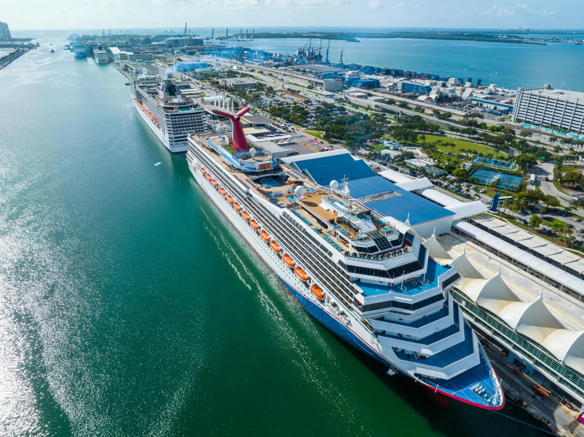 Aerial view of a cruise ship docked at a PortMiami terminal with the Miami skyline